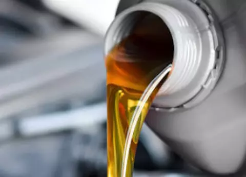 Frisches goldenes Motorenöl wird aus einem Kanister gegossen